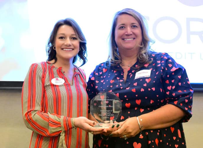 Junior League representative standing with Paula O'Rourke holding Community Champion award