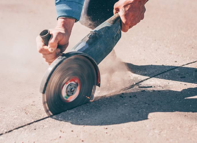 Man using saw on concrete