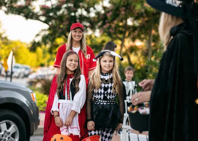 Mom and daughters trunk or treating in costumes