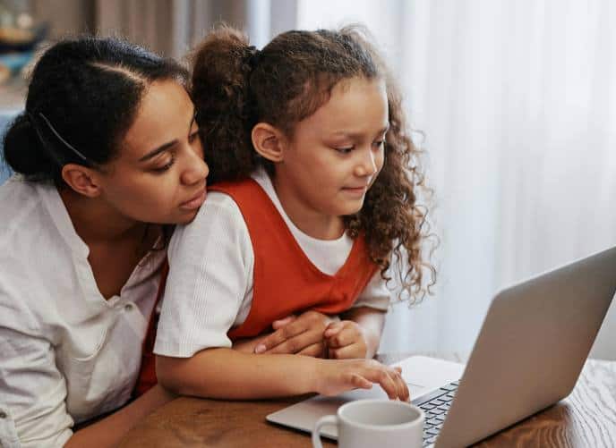 Woman and young girll looking at laptop